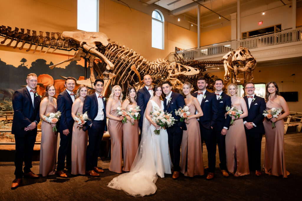bridesmaids and groomsmen with the couple in front of dinosaurs at the CMOA • Carnegie Museum of Art and Natural History Weddings