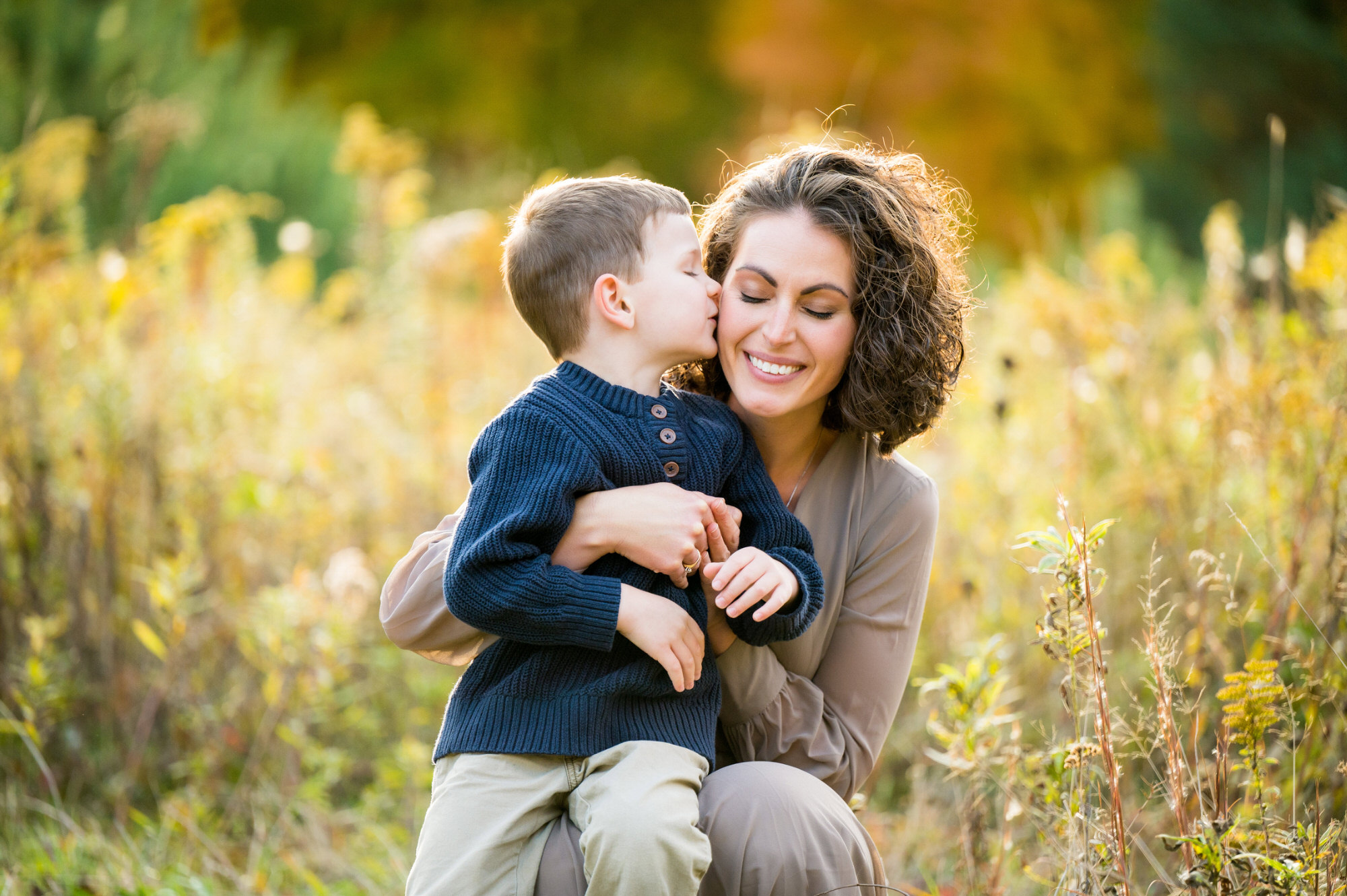 son kissing mom on cheek during autumn family photos in pittsburgh • Family